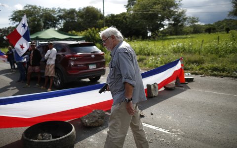 Un hombre sostiene un arma en medio de un bloqueo de docentes en la vía Panamericana hoy, en Chame (Panamá).