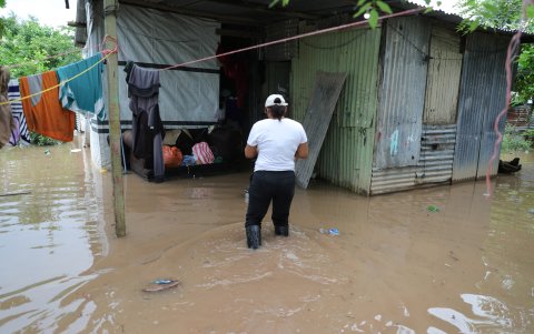 Una mujer camina dentro de su casa inundada hoy, en la Colonia Jehová Jireth del municipio de San Manuel, departamento de Corte (Honduras).