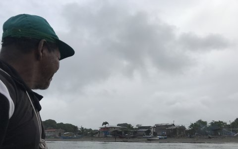 Uno de los habitantes del Cauchal observa desde lejos el caserío al pie del mar.