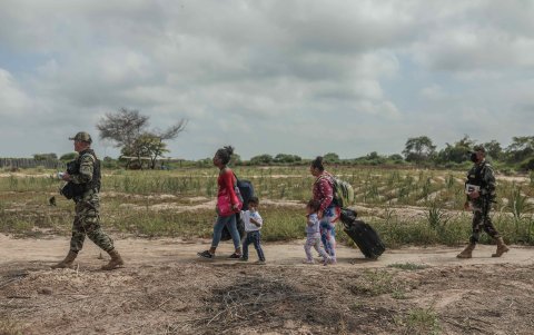 Un grupo de personas de origen venezolano son escoltados por elementos de la policía de Perú en Tumbes, fronterizo con Ecuador.