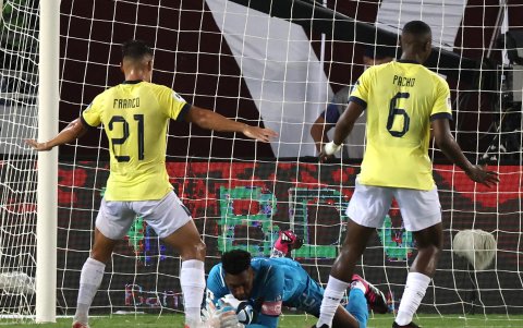 Alexander Domínguez (abajo) portero de Ecuador atrapa un balón hoy, en un partido de las Eliminatorias Sudamericanas para la Copa Mundial de Fútbol 2026 entre Venezuela y Ecuador en el estadio Monumental en Maturín (Venezuela).