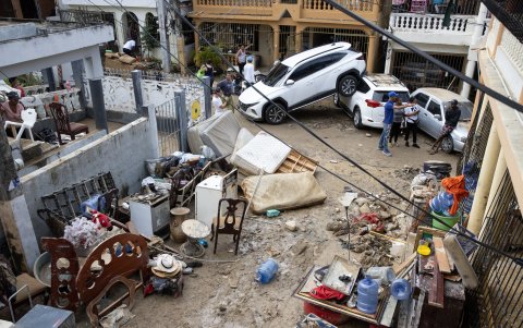 Personas quitan el lodo de sus muebles, junto a varios vehículos que fueron arrastrados por la corriente, hoy en Santo Domingo (República Dominicana).