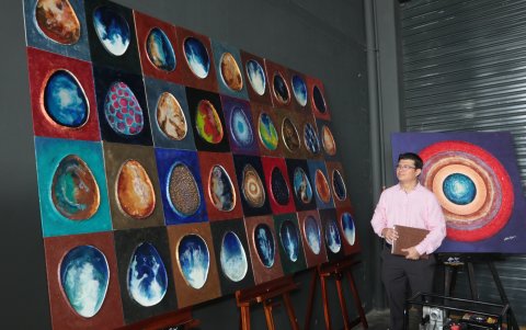 El artista plástico Arturo Rojas junto a sus obras que se expusieron en el lugar.