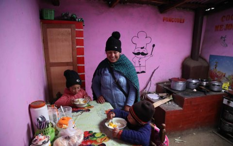 Evelyn López y sus dos hijos comen en su vivienda de la comunidad San José de Apata, a más de 3.500 metros de altura y perteneciente a la región de Junín