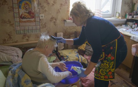La trabajadora social Valentina Panova ayuda a lavarse a Vira Hodun, que tiene problemas de movilidad, en la localidad de Kosivshchina, en la región de Sumi del noreste de Ucrania.