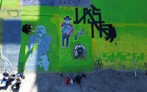 Fotografía aérea de activistas pintando un mural para denunciar la violencia de género y el maltrato a los migrantes, junto al río Bravo en Ciudad Juárez, hoy en el estado de Chihuahua (México).