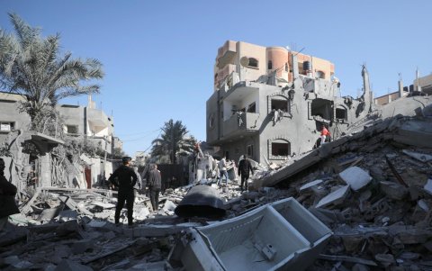 Palestinos buscan víctimas y supervivientes entre los escombros de las casas destruidas.