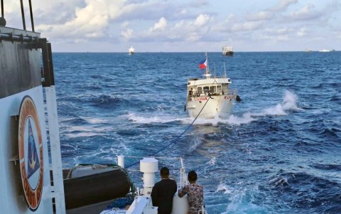 Un barco de la Guardia Costera de Filipinas remolcando un barco de suministro operado por la Armada de Filipinas (D) después de que sus motores sufrieran daños debido a los cañones de agua.