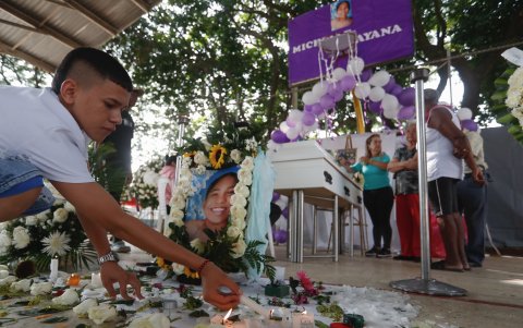 Una docena de velas, una veintena de ramos de flores y pancartas exigiendo justicia rodean el féretro de Michelle Dayana González, la niña de 14 años.