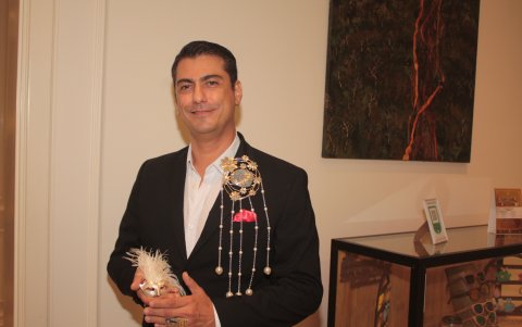 Adorno. David Ramón, diseñador de joyas, luce un adorno para novio y muestra otro en la mano.