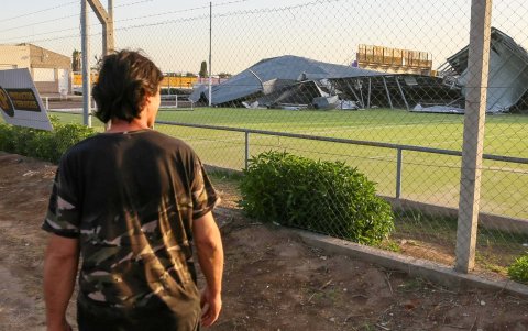 Un residente mira desde lejos los daños causados en el club Tiro Federal por un temporal el sábado, en Bahía Blanca, provincia de Buenos Aires (Argentina).