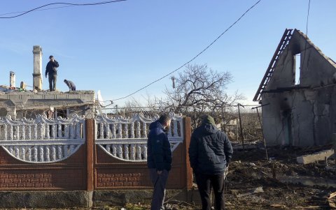 Varias personas recorren una zona con edificios dañados en el lugar de un ataque nocturno con drones en Odesa, sur de Ucrania, el 17 de diciembre de 2023, en medio de la invasión rusa.