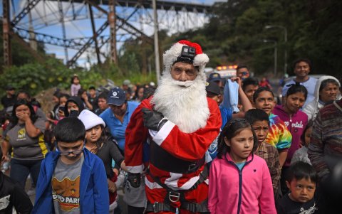 El mayor de los Bomberos Municipales, Héctor Chacón, saluda a niños y niñas de escasos recursos en el asentamiento Jesús de la Esperanza, en Ciudad de Guatemala (Guatemala).