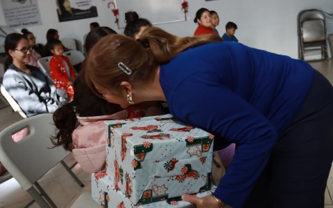Una activista reparte regalos a migrantes que pasan la Navidad en el albergue 'El buen samaritano', el 24 de diciembre de 2023, en Ciudad Juárez Chihuahua (México).