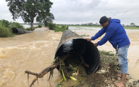 Trabajadores del Gobierno Provincial de Los Ríos procuran volver a colocar los tubos de alcantarilla en la zona del río Las Juntas.