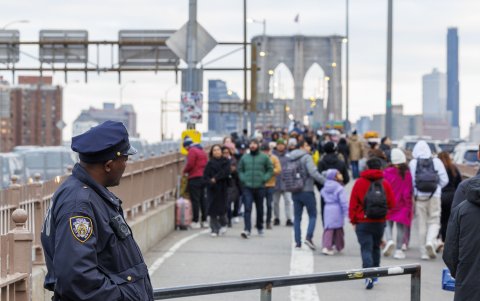 Un oficial de policía observa personas caminando por el puente de Brooklyn sin vendedores a la vista en Nueva York