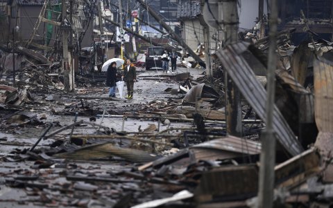 Varias personas recorren una zona de la ciudad de Wajima, donde aparecen restos de edificaciones destruidas.