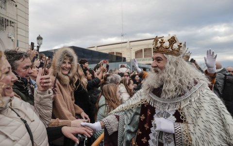 El Rey Melchor saluda a niños y también padres que en Valencia se han acercado hasta el puerto para ver llegar a los reyes, que protagonizan una cabalgata previa a la noche más mágica del año.