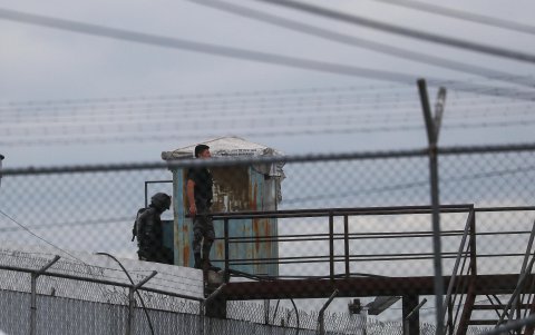 Agentes del servicio penitenciario vigilan desde una garita hoy, tras un amotinamiento de presos, en Quito (Ecuador).