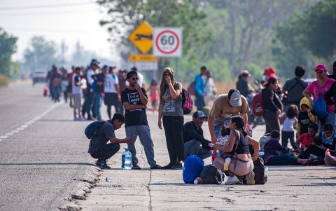 Varios migrantes se toman un descanso durante una caravana que se dirige a la frontera con Estados Unidos, en el municipio de Arriaga (México).