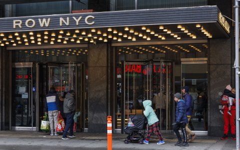 Personas con bolsas entran en el hotel Row NYC, uno de los sitios destinados para albergar migrantes irregulares.