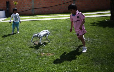 Niños juegan con un perro robot en el museo Creators, el 11 de enero de 2024, en Achocalla