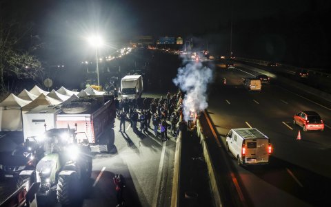 Decenas de tractores estacionados detrás de unas carpas instaladas para que los manifestantes pasaran la noche en la autopista A-15 en Argenteuil, al norte de París, Francia, este 29 de enero de 2024.