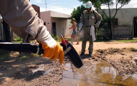 Un par de trabajadores sanitarios fumigan una calle en el barrio Popular, como medida preventiva para combatir la propagación del dengue, en la ciudad de Corrientes (Argentina).