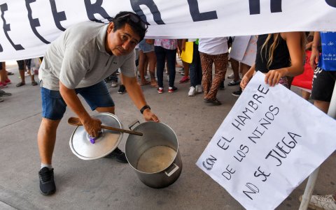 Un hombre muestra una enorme olla vacía a modo de protesta, durante una manifestación en los exteriores del supermercado Coto, en la localidad de Ciudadela, provincia de Buenos Aires (Argentina).
