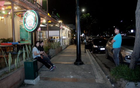 Zonas. Peatones descansan junto a un local en la avenida Víctor Emilio Estrada.
