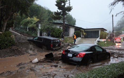 Vraias personas intentan limpiar los escombros de un deslizamiento de tierra mientras una poderosa tormenta fluvial atmosférica golpea el sur de California en Beverly Hills, California.