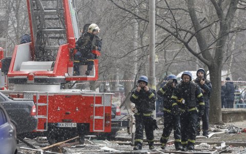 Bomberos y rescatistas llegan al lugar de un edificio dañado por la caída de escombros de un misil ruso derribado tras un ataque en Kiev, el 7 de febrero de 2024, en medio de la invasión rusa.