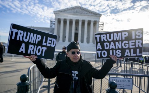 Un manifestante sostiene una pancarta frente a la Corte Suprema mientras los jueces se preparan para escuchar los argumentos en Trump contra Anderson, en Washington, DC, EE.UU., 08 de febrero de 2024.