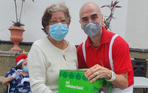 Daniel Tapia junto a una adulta mayor en un evento por Navidad.