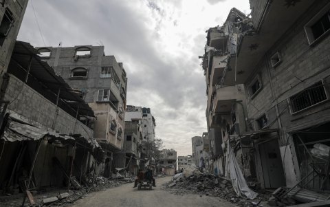 Palestinos sentados en un carro de caballos pasa por casas destruidas durante una operación militar israelí en el campo de refugiados de Al Bureije.