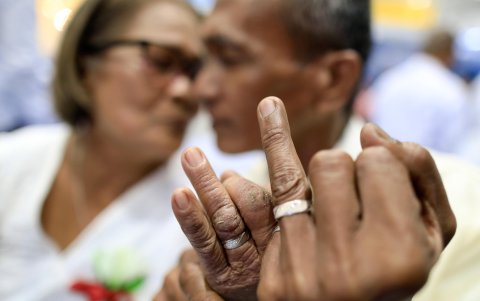 El novio George Guettap besa a su novia Yolanda durante una boda masiva el día de San Valentín en la ciudad de Bacoor.