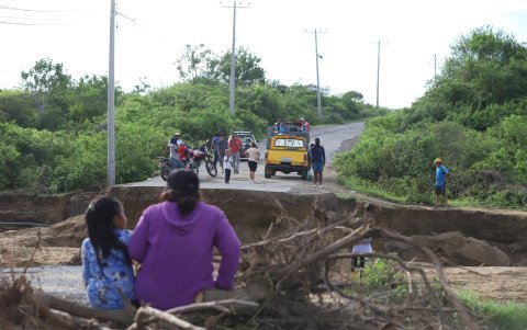 Moradores observan el corte de la carretera tras la caída de uno de los puentes que conectaba a la comunidad de Engabao y el puerto.