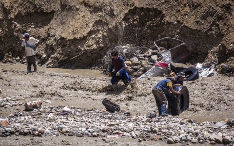 Personas intentan recuperar sus pertenencias en una zona afectada por la crecida del río Irpavi este jueves, en La Paz (Bolivia).