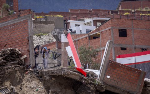 Una pareja observa desde un área afectada por la crecida del río Irpavi, en La Paz (Bolivia).