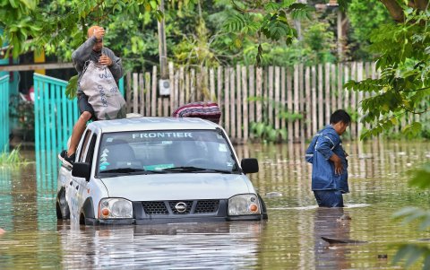 Una persona salva sus cosas luego de que el  vahículo se quedara atacado después que el río Acre aumentara su caudal, en Cobija en el departamento de Pando (Bolivia).