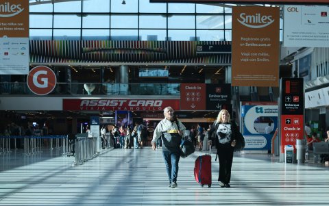 Pasajeros caminan por una sección del Aeropuerto Internacional Ministro Pistarini durante una jornada de paro este miércoles, en Ezeiza, provincia de Buenos Aires (Argentina).