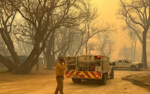 Un bombero se comunica con su equipo en una zona cercana a la zona de incendios.