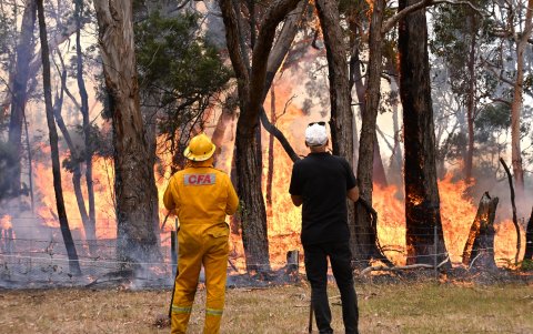 Un residente local y un bombero observan un incendio cerca de una propiedad en Raglan, Victoria, Australia, el 29 de febrero de 2024.