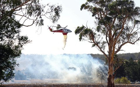Un helicóptero de extinción de incendios combate un foco de fuego en las afueras de Beaufort, Victoria, Australia, 28 de febrero de 2024.