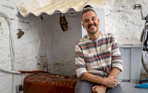 Ismael Fernández, técnico de turismo y cultura del municipio de El Borge y presidente de la asociación Amigos de la Galería del Bandolero posa en el pozo