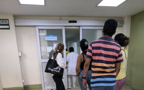Familiares de pacientes se aglomeran frente a la puerta de quirófano central de la institución, La sala de espera está sin climatización.