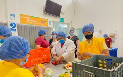 Mujeres clasifican y distribuyen frutas que, posteriormente, son para niños de la comunidad.