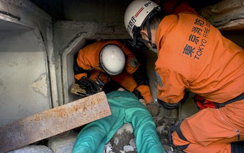 Efectivos del cuerpo de bomberos de Tokio llevan a cabo una demostración del rescate de una víctima atrapada bajo escombros
