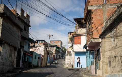 Una joven vestida con uniforme escolar camina en una calle de una zona popular, este miércoles en Caracas.