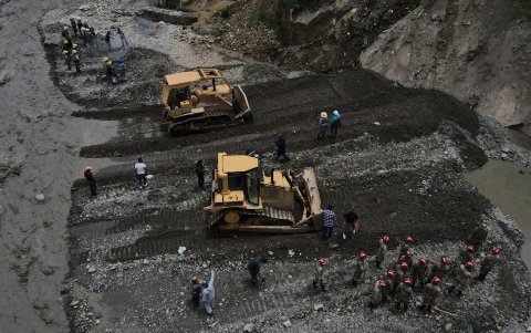 Fotografía que muestra a militares mientras trabajan con maquinaria cerca de casas colapsadas por la crecida de ríos en la zona Callapa, el 23 de febrero de 2024, en La Paz (Bolivia).